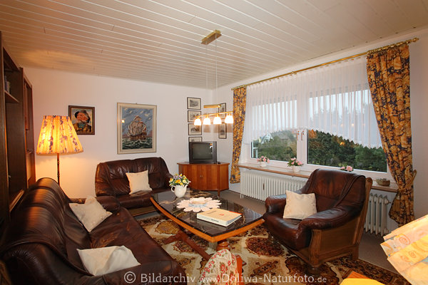 Wohnzimmeridylle Sitzecke in Holz Ledergarnitur in Licht unter Fensterpanorama
