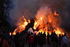 700555_ Osterfeuer Gehölzer Haufen in Brand & Flammen Gewalt, Menschen vor rauchendem Feuer