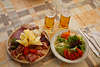 106314_Jause aus Wurstsorten Speck mit Käse auf Brett Foto mit Salatteller zum Bier in Gläser serviert