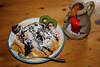 004601_Palatschinke Dessertteller mit Schokoladensoße, Vanillensoße Foto auf Holztischbrett bei Kerze