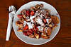 Kaiserschmarrn mit frischen Erdbeeren süsse Speise super Leckerei Teller auf Holzplatte