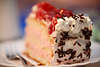 800004_ Obstsahnetorte Tortenstück auf Teller mit Gabel als Dessertkuchen zum Kaffee, Geburtsstagstorte Tip