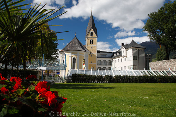 Gelbe Spitalskirche in Lienz sonnige Grünwiese Palmen südliche Blumen Stadtmauer