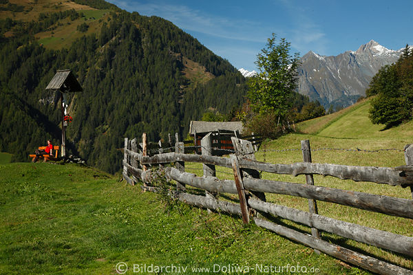 Almwiese Holzzaun Wanderin unterm Marterl Kreuz in Alpenlandschaft Virgental Naturfoto