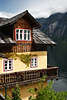 Hallstatt alte Bürgerhäuser Holzdächer Holzbalkone über Seewasser mit Bergblick