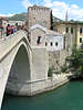 Bd0100_ Mostar Bild: Mann springt von hohen Neretva-Brücke in die Tiefe des grünen Flusswasser Foto