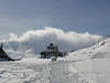 Sennhtte in Schneelandschaft am Skipfad Wanderpfad unter Wolke ber Berg bei Wetterumschwung