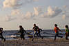Mdchen mit Jungs am Strand laufen lachend Foto Spass am Meer Wellen Gischt Seeufer