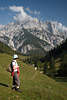 913312_Bergwanderer Photos Frau auf grner Almwiese vor imposanten Felsbergen & Talblick