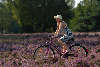 Model mit Sonnenhut Fahrrad fahren in blhender Heide