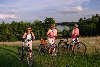 57343_Frauen Trio mit Fahrrder vor See in Masuren