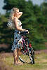 Blondes Frulein im Kleid stehen mit Sonnenhut Foto hbsches Mdchen am Fahrrad Portrt auf Wanderweg