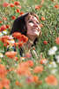 Frau im Klatschmohn frhlich sonnen, Hoffnung Freude in Rotblumen lcheln in Blumenfeld sitzen