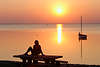 Seeufertisch Frau in roter Sonnenuntergang ber Boot in Wasser