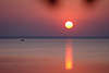 Sonne ber Seewasser rosarot Abendfarben mit Fischerboot