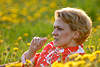 Blondine hbsche Frau im Bltenfeld Foto mit Grashalm im Mund liegen in Blumen