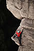710173_ Kletterer Foto Hnde & Fsse breit an Steilwand geklebt Felsvorsprung klettern vor dunklem Abgrund