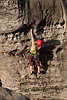 710187_ Frau Alpinistin, Kletterin an Bergwand, Felswand mit Lchern & Spalten mit Haken & Seilen hngen und klettern