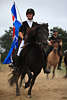 000906_Islandpferde Ritt Prsentation Foto junge Reiterin mit Fahne im Galopp Portrt auf schwarzem Islandpferd