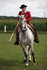 000411_Stiertanz-Reiterin Portrt mit Lanze weissgrauen Barockpferd reiten in rot-braun Reitkleid und Hut