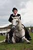 000495_Rittmeisterin Portrt mit Weisspferd Schaubild auf Barockpferd im Liegen Reitdame elegante Pferdebeherrschung