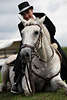 000496_Seniorin spanischen Reitkunst Bild Reitdame im Hut auf liegendem Pferd, Weisspferd Portrt nach Verneigung vor Pferdefans