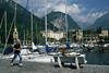 Riva Yachthafen Gardasee Promenade Jogger Lauf in Bergkulisse neben Frau auf Bank